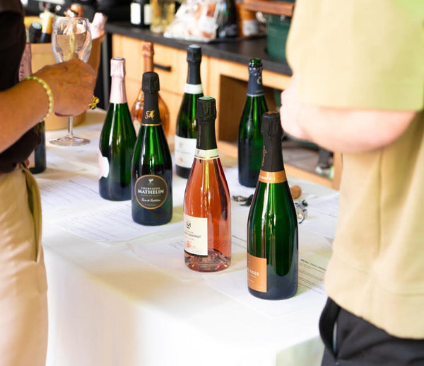 Champagne proeverij met diverse flessen op tafel, inclusief rosé en groen etiket